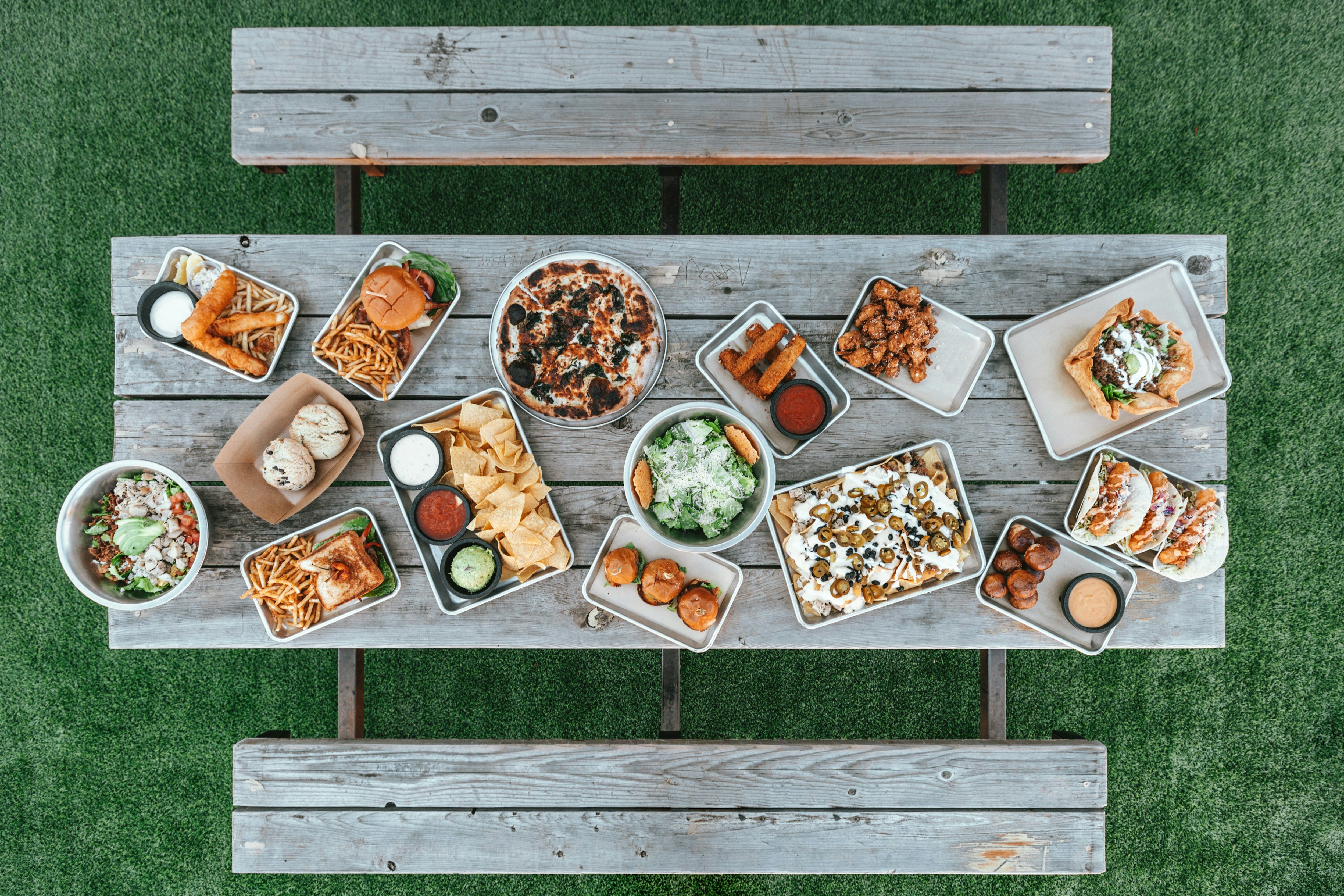 a picnic table with a variety of food on it